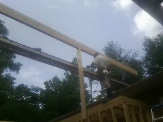Carpenter setting a ridge beam over a new addition frame — Ice Dam Removal by Roofing Brothers in Cheswick