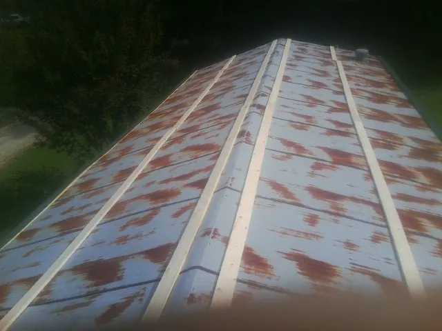 Rusted metal roof panels with new wood purlins before replacement — Storm Damage Roof Repair in Cheswick by Roofing Brothers