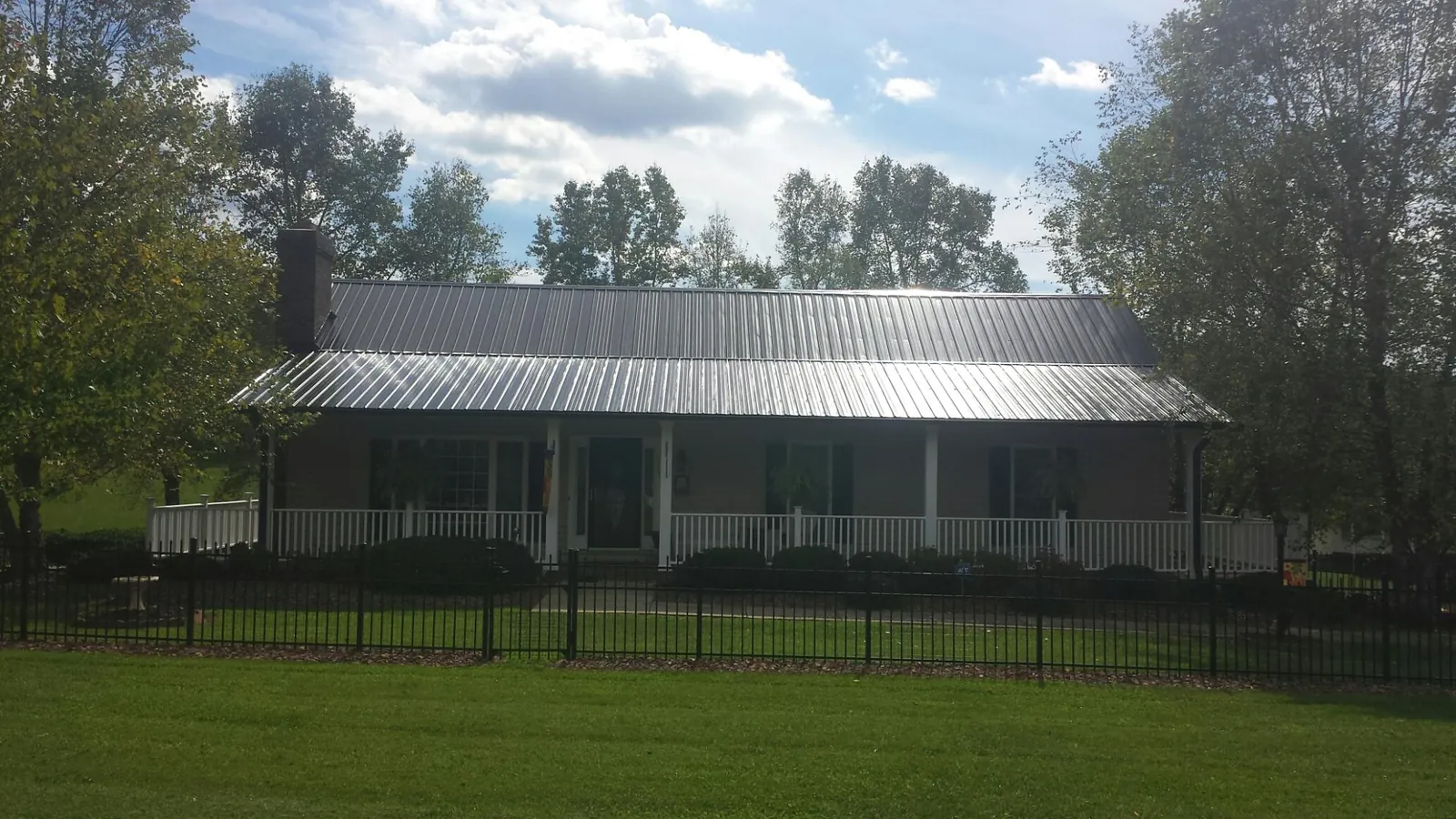 Gray metal roof on a brick ranch with a full width front porch — Gutter Guard Installation work by our crew in Cheswick