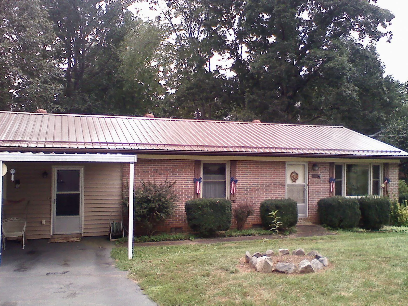 Bronze metal roof and carport on a brick ranch home — Roof Repair work by our crew in Cheswick
